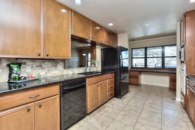 kitchen with brown cabinetry, baseboards, a sink, black appliances, and backsplash