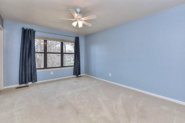 carpeted empty room with visible vents, baseboards, and ceiling fan