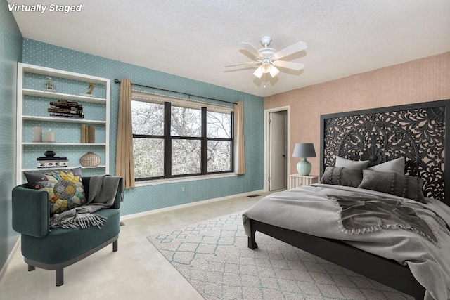 carpeted bedroom with visible vents, wallpapered walls, baseboards, a textured ceiling, and a ceiling fan