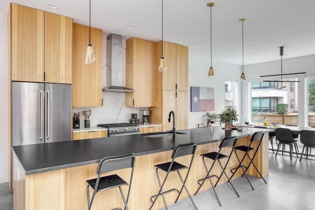 kitchen with a sink, wall chimney range hood, decorative backsplash, stainless steel appliances, and modern cabinets