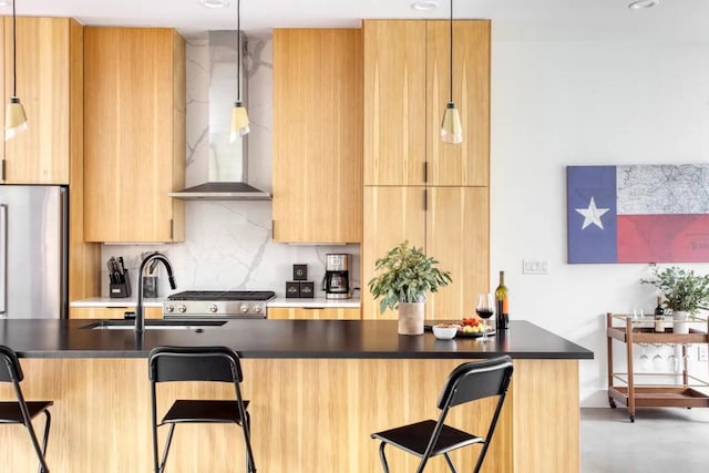 kitchen with dark countertops, tasteful backsplash, a breakfast bar, modern cabinets, and wall chimney exhaust hood