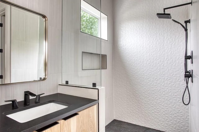 full bath with vanity and a tile shower