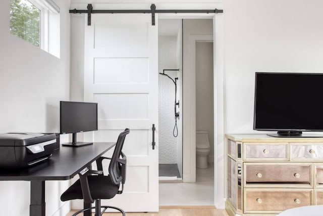 office featuring a barn door and light wood-style flooring