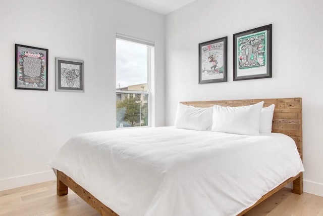 bedroom featuring baseboards and wood finished floors