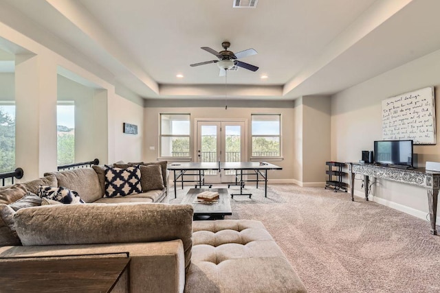 carpeted living area featuring visible vents, baseboards, recessed lighting, a raised ceiling, and a ceiling fan