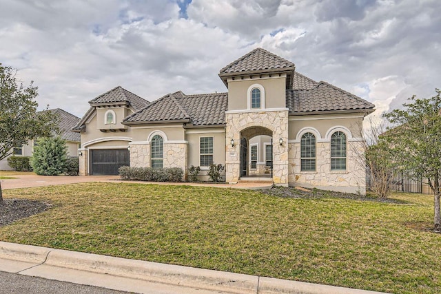 mediterranean / spanish-style house featuring a tile roof, a front lawn, stone siding, and stucco siding