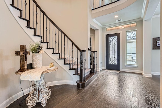 foyer entrance featuring crown molding, stairs, baseboards, and wood finished floors