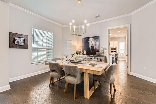 dining space featuring dark wood finished floors, crown molding, a notable chandelier, and baseboards