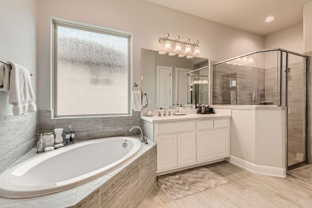 full bath featuring a bath, plenty of natural light, a shower stall, and vanity