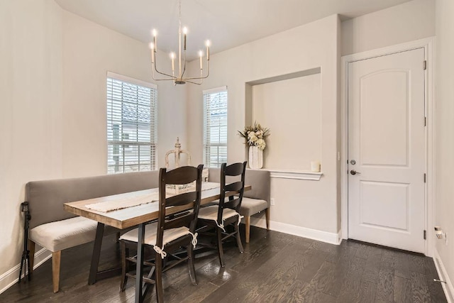 dining room with a chandelier, dark wood-type flooring, and baseboards