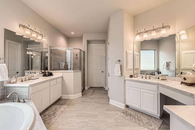 bathroom featuring a bath, a stall shower, two vanities, and a sink