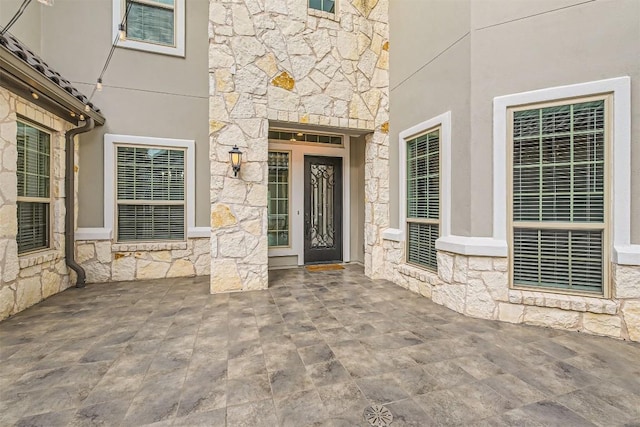 921 Morning Moon Cir, Austin, TX 78732 - property entrance featuring stone siding, a patio area, and stucco siding