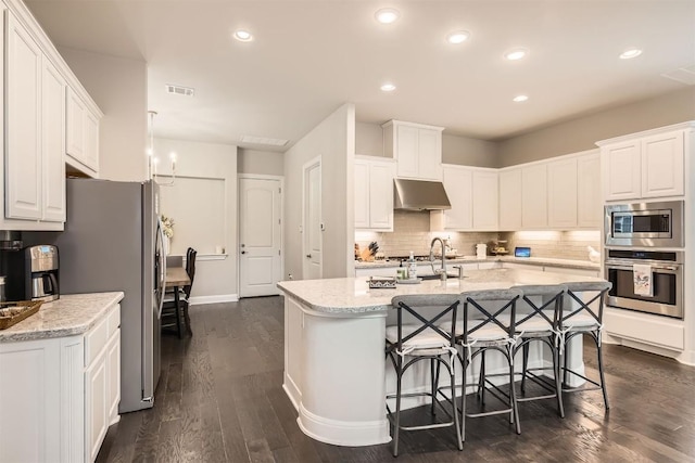 921 Morning Moon Cir, Austin, TX 78732 - kitchen with appliances with stainless steel finishes, under cabinet range hood, dark wood finished floors, white cabinetry, and recessed lighting
