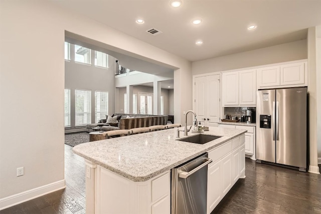 921 Morning Moon Cir, Austin, TX 78732 - kitchen featuring appliances with stainless steel finishes, a sink, light stone countertops, white cabinetry, and recessed lighting