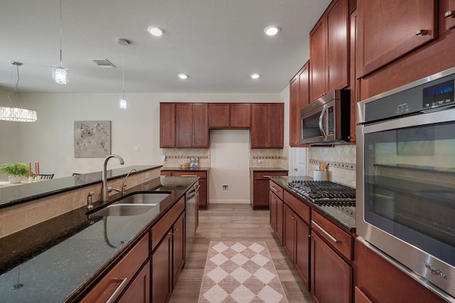 404 Buttercup Creek Blvd Unit 10, Cedar Park, TX 78613 - kitchen featuring stainless steel appliances, a sink, dark stone counters, decorative light fixtures, and tasteful backsplash