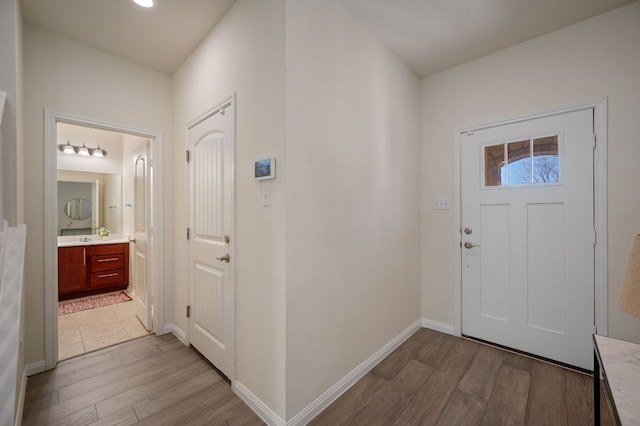 foyer with light wood-type flooring and baseboards