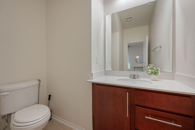 half bathroom with vanity, baseboards, visible vents, tile patterned floors, and toilet