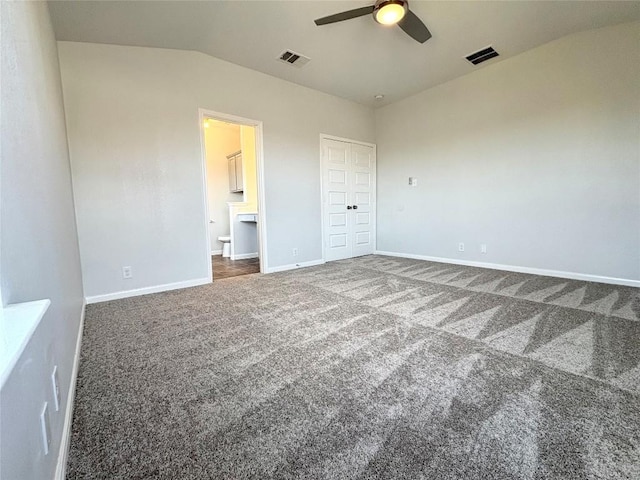 unfurnished bedroom featuring lofted ceiling, baseboards, visible vents, and carpet floors