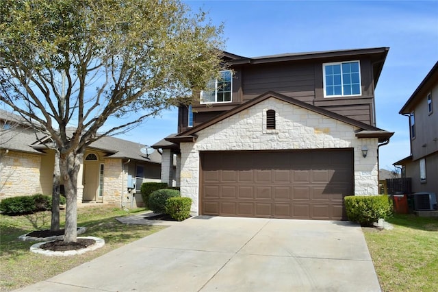 traditional-style house featuring stone siding, central air condition unit, concrete driveway, and a garage