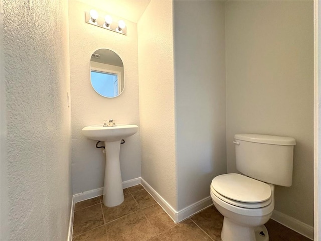 bathroom featuring tile patterned floors, toilet, and baseboards