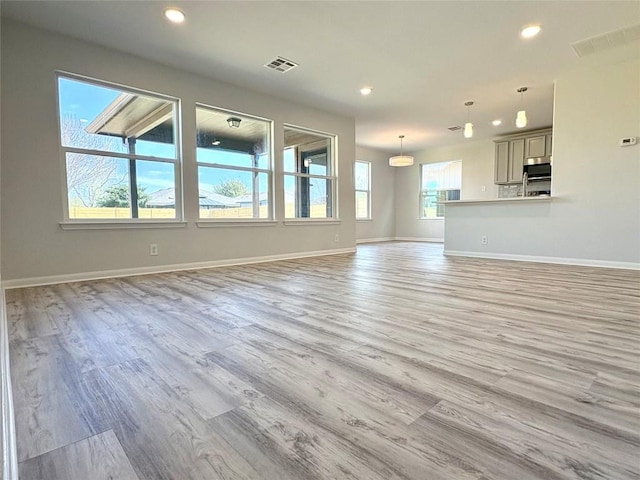 unfurnished living room with light wood-style flooring, recessed lighting, baseboards, and visible vents