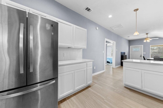 kitchen with visible vents, white cabinetry, freestanding refrigerator, light countertops, and ceiling fan