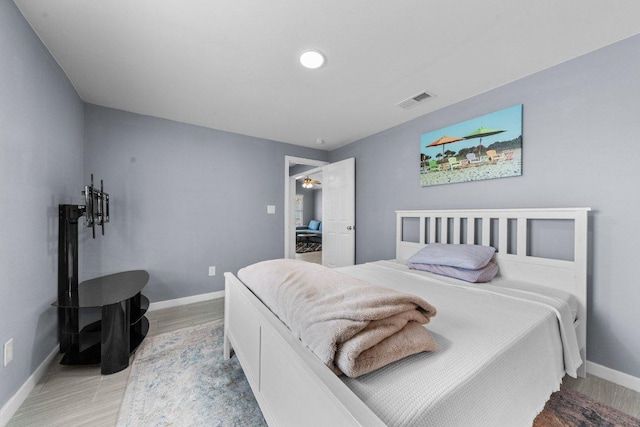 bedroom with visible vents, light wood-style floors, and baseboards