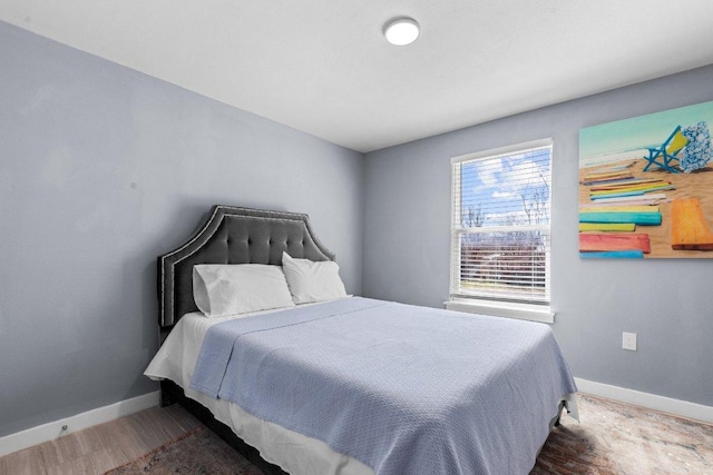 bedroom with baseboards and wood finished floors