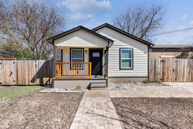 bungalow-style house featuring covered porch and fence