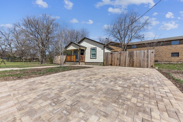 view of front of property with decorative driveway and fence