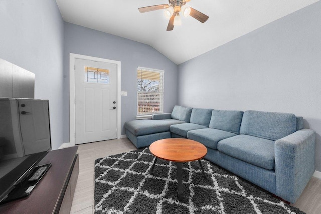 living room with vaulted ceiling, baseboards, light wood-type flooring, and ceiling fan