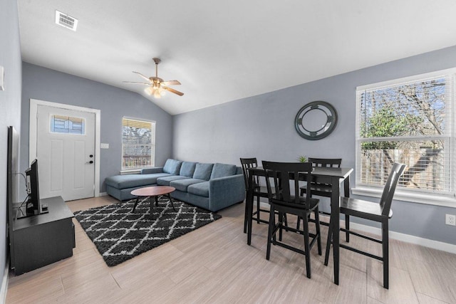 living room featuring visible vents, baseboards, lofted ceiling, and a ceiling fan