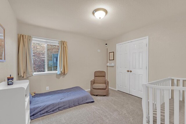 carpeted bedroom with baseboards and a closet