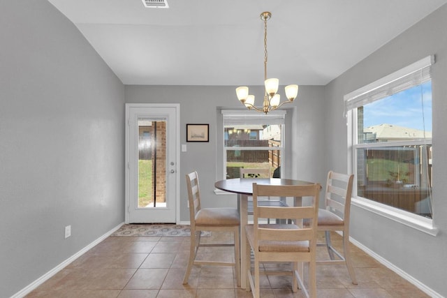 dining area featuring light tile patterned flooring, a healthy amount of sunlight, baseboards, and an inviting chandelier