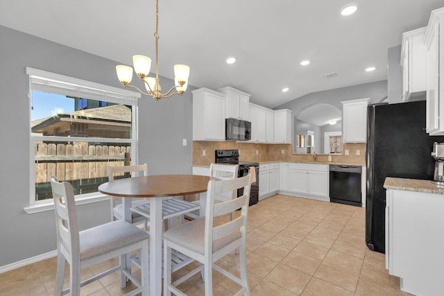 kitchen featuring a wealth of natural light, decorative backsplash, black appliances, and lofted ceiling