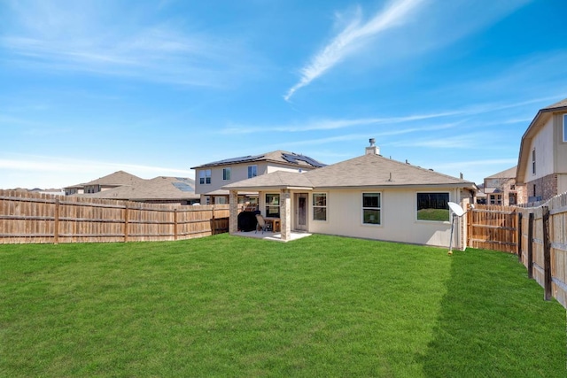 rear view of house featuring a patio area, a lawn, and a fenced backyard