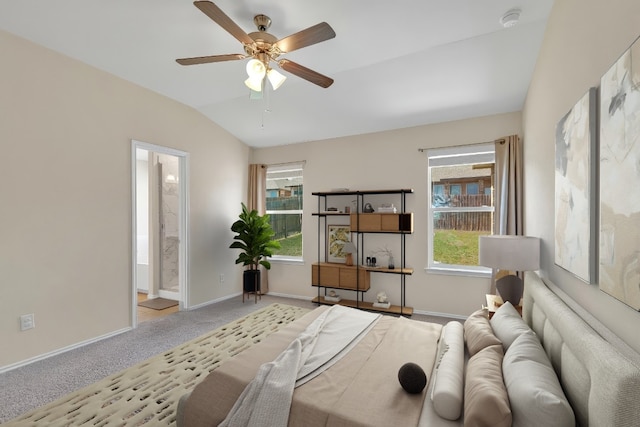 carpeted bedroom featuring connected bathroom, baseboards, ceiling fan, and vaulted ceiling