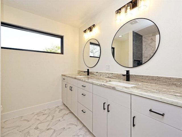 full bath with double vanity, baseboards, marble finish floor, and a sink