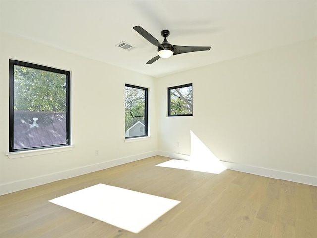 spare room with visible vents, baseboards, light wood-style floors, and ceiling fan