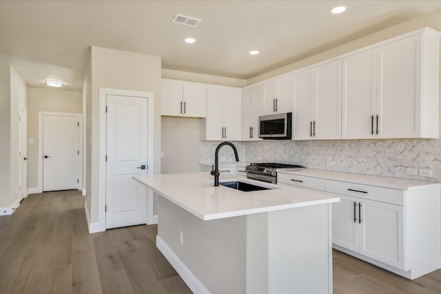 5300 Traviston Dr, Austin, TX 78738 - kitchen with stainless steel appliances, a sink, decorative backsplash, white cabinetry, and recessed lighting