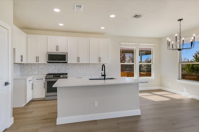 5300 Traviston Dr, Austin, TX 78738 - kitchen featuring appliances with stainless steel finishes, a sink, tasteful backsplash, a chandelier, and light wood finished floors