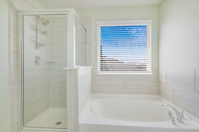 bathroom featuring a garden tub and a stall shower