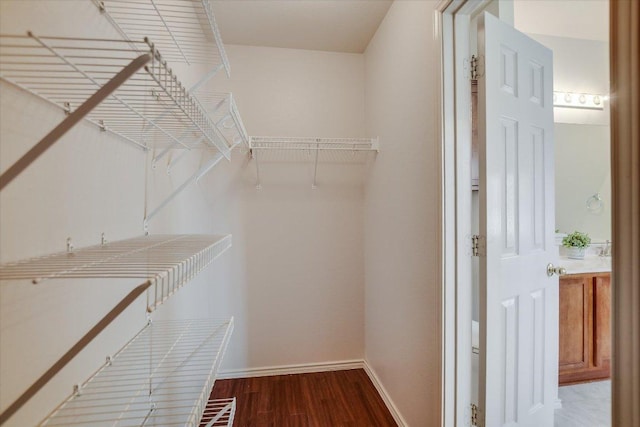 walk in closet with wood finished floors