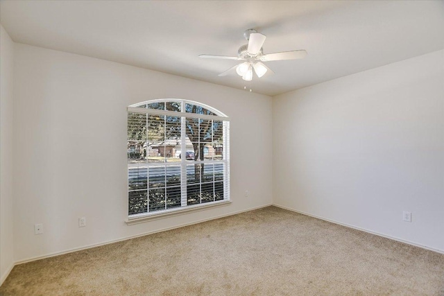 empty room with a ceiling fan and carpet flooring