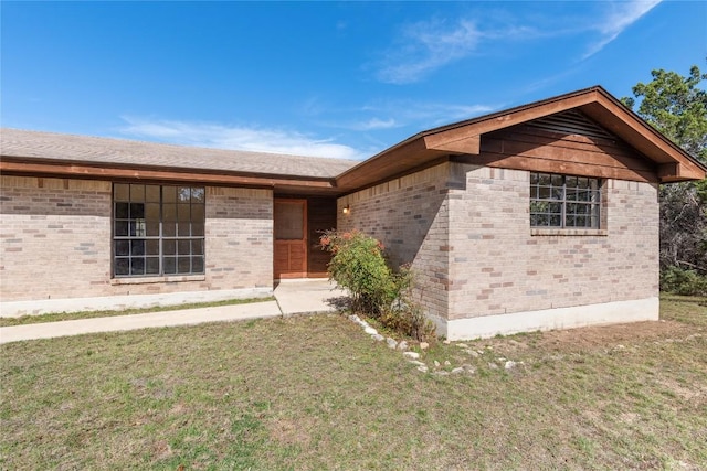 ranch-style home featuring brick siding and a front yard