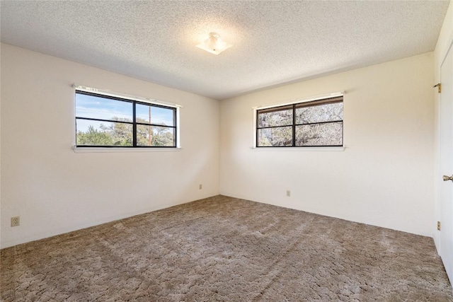 carpeted empty room featuring a textured ceiling