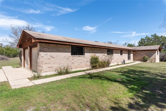 view of home's exterior featuring an attached garage, a lawn, and brick siding