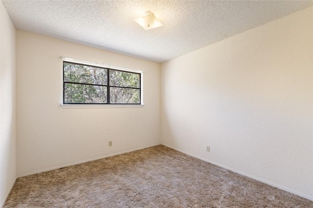 carpeted empty room featuring a textured ceiling