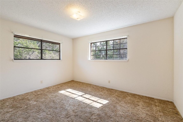 empty room with a textured ceiling and carpet