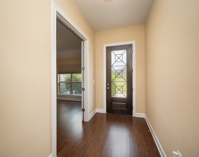 foyer entrance featuring dark wood finished floors and baseboards